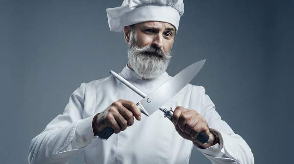 Editorial illustration for Whetstones, Guided Systems, Electric, or Pull-Through: Which Knife Sharpener Fits Your Skill and Your Blades